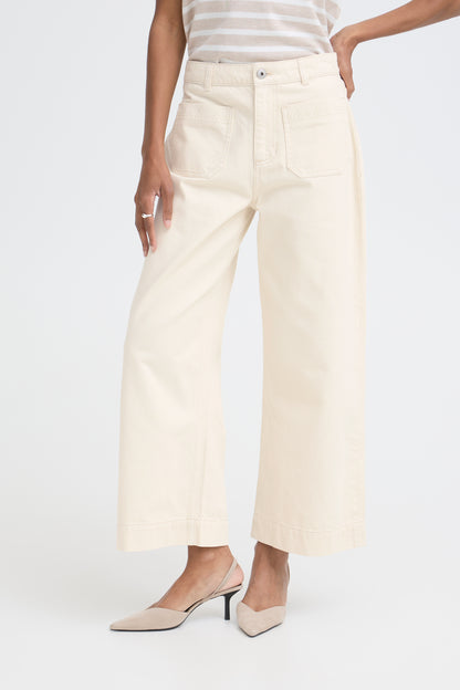 Person wearing cream-colored wide-leg pants on a white background