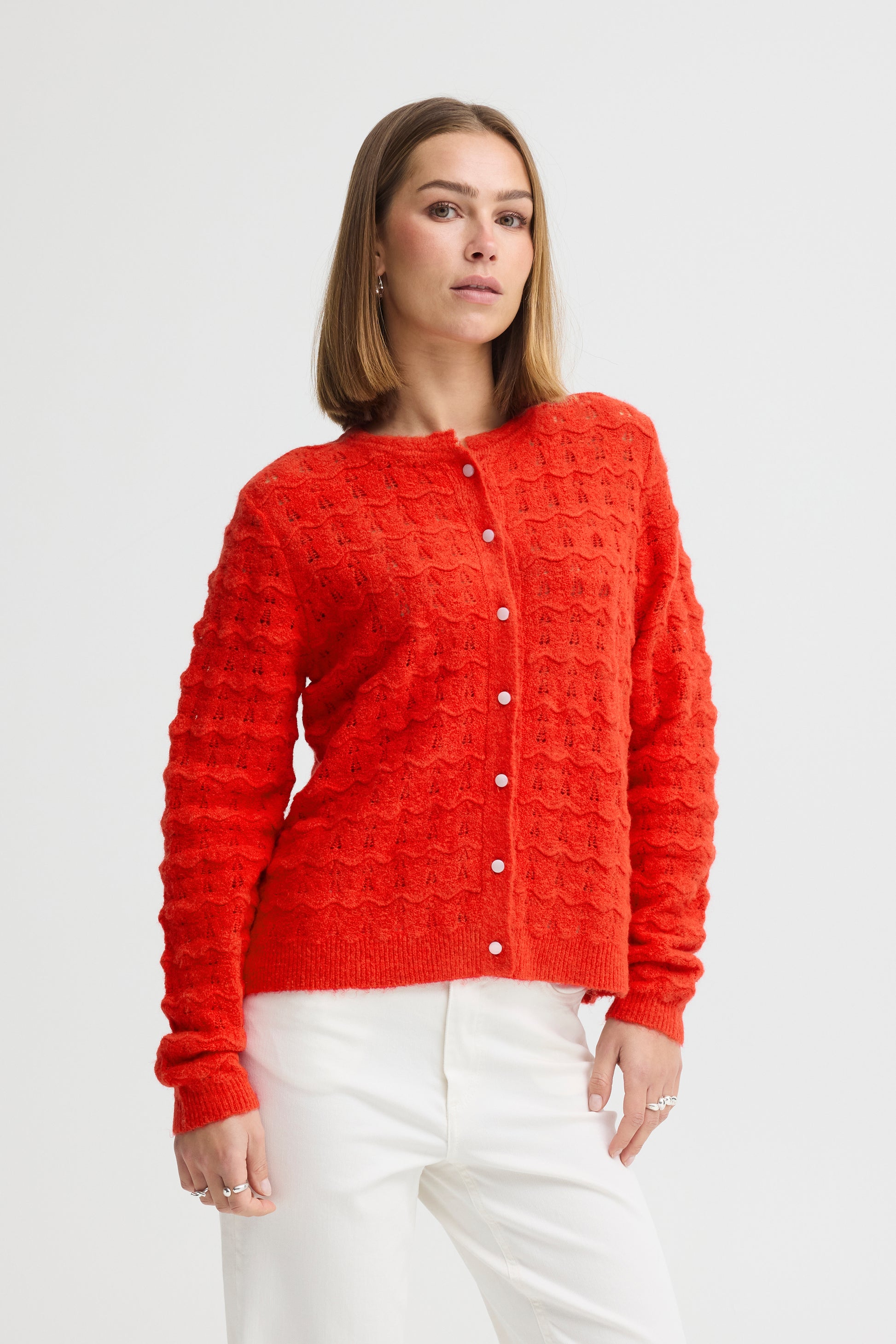 Woman wearing a red textured cardigan on a white background