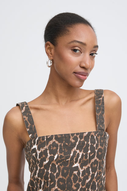 Woman wearing a leopard print dress against a plain background
