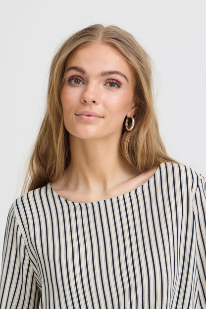 Woman wearing a black and white striped shirt against a plain background