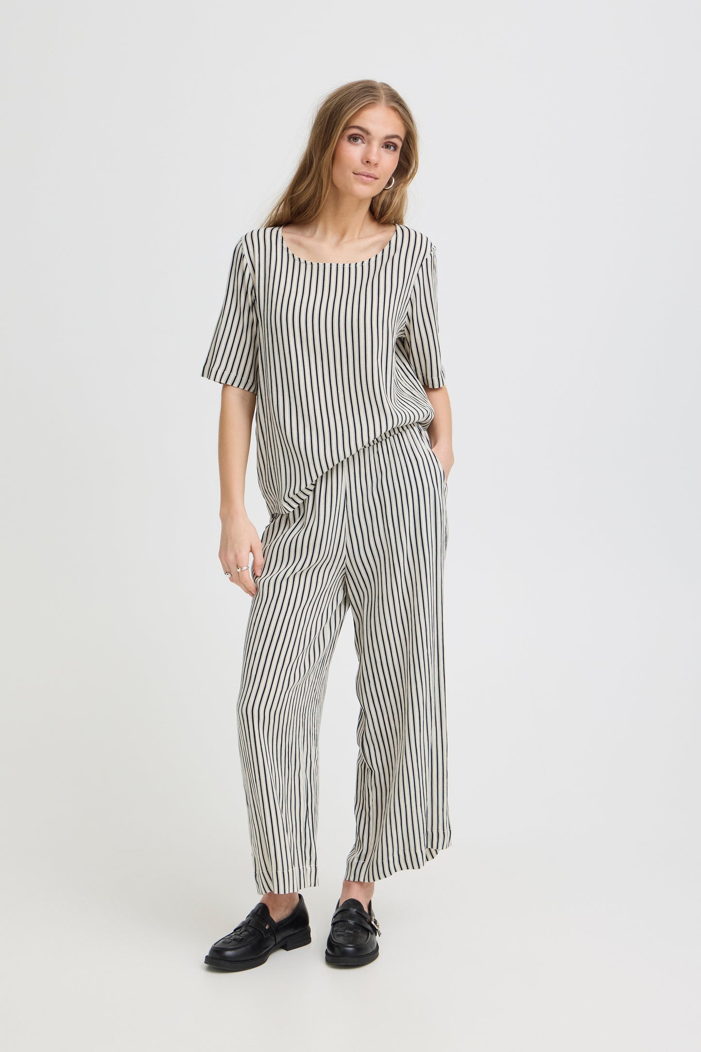 Woman wearing a black and white striped outfit on a white background