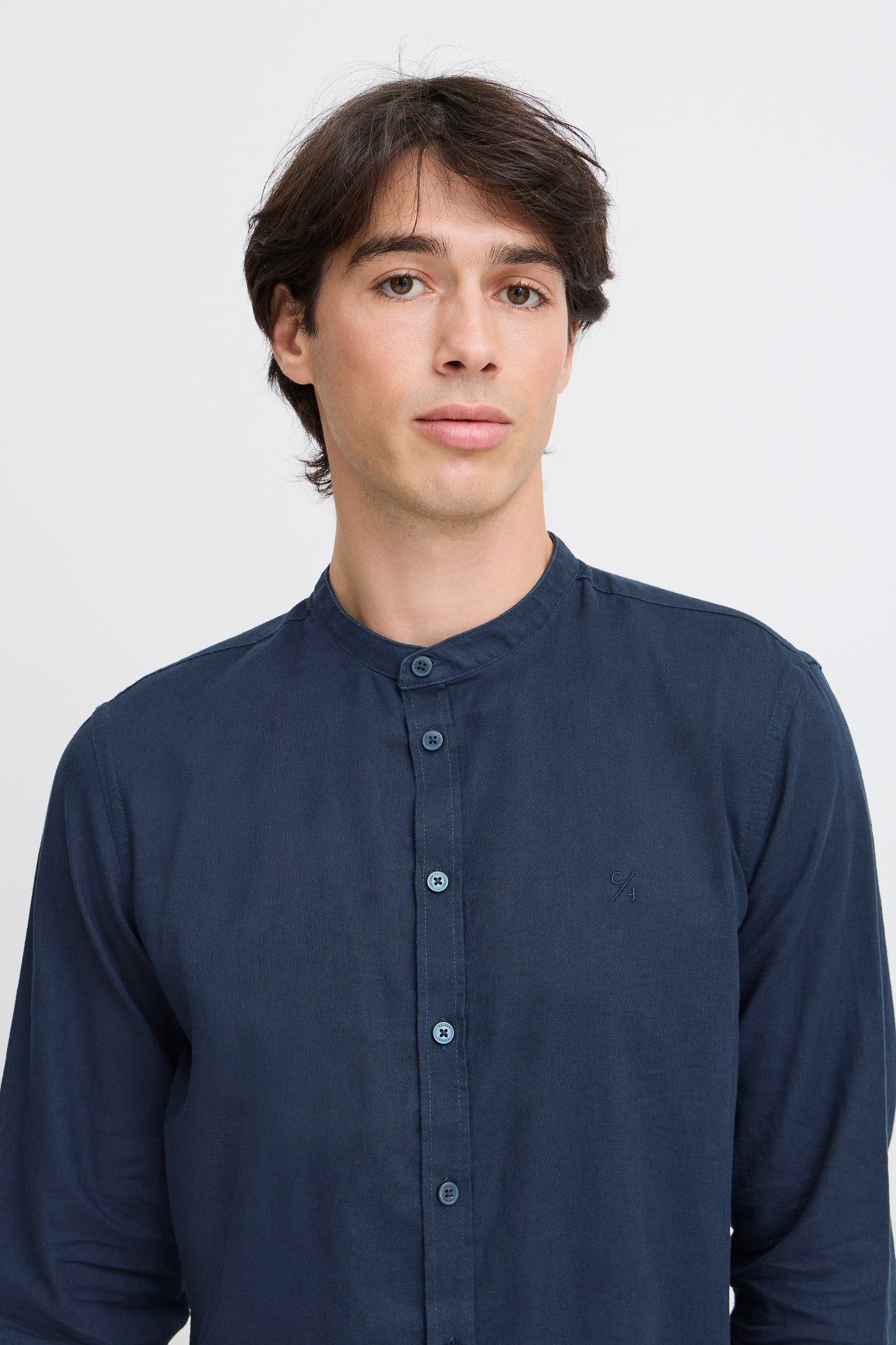 Man wearing a navy blue long-sleeve shirt against a white background