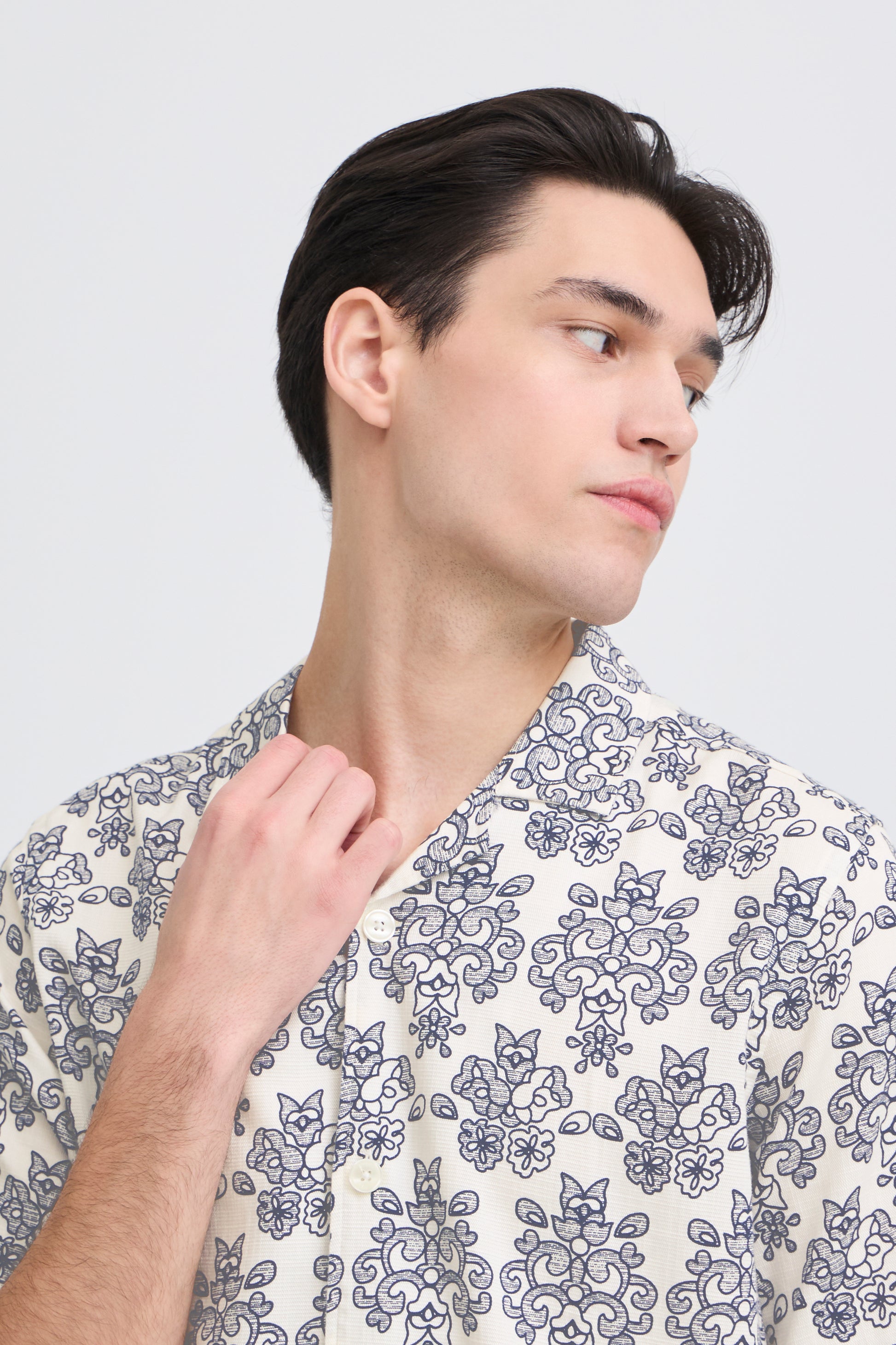 Man wearing a patterned shirt against a plain background