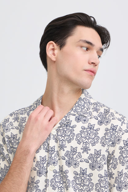Man wearing a patterned shirt against a plain background