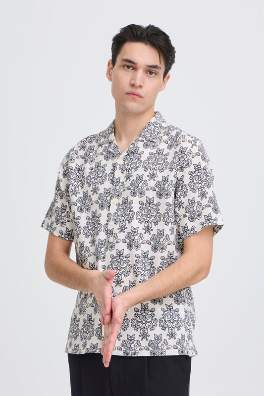 Man wearing a patterned shirt on a plain background