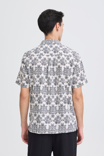 Person wearing a patterned shirt on a white background