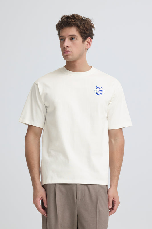 Man wearing a white t-shirt with text on a plain background