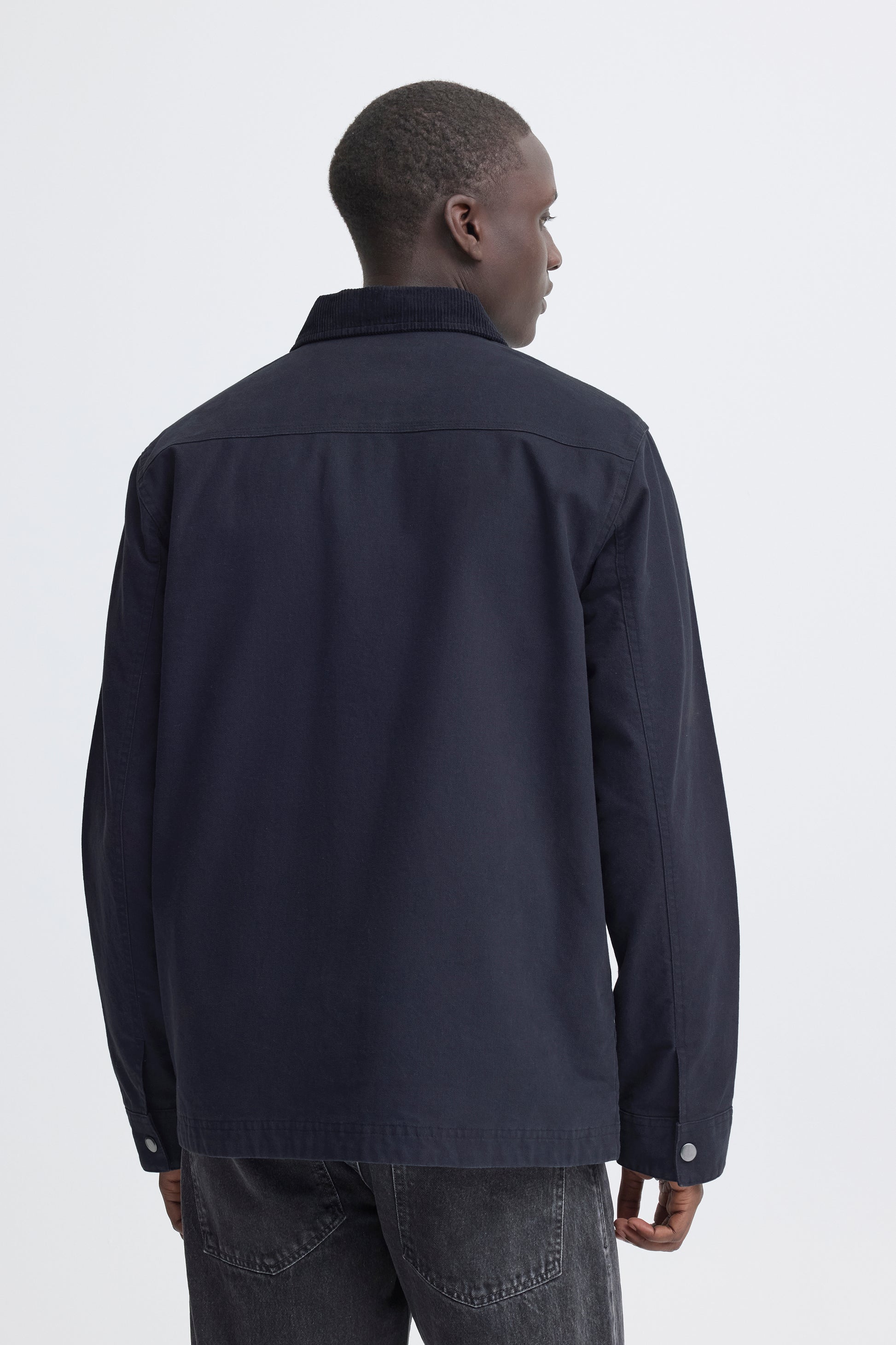 Man wearing a dark jacket on a white background