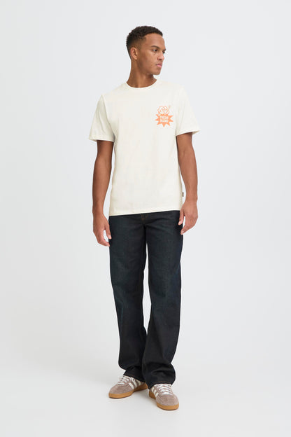 Man wearing a white t-shirt with a logo and dark jeans on a white background