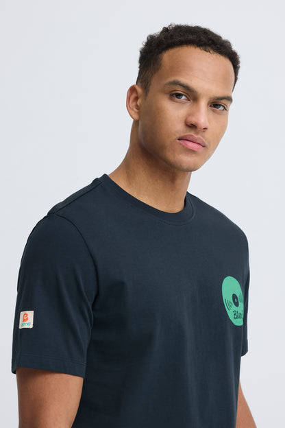 Man wearing a black t-shirt with a green logo on a white background