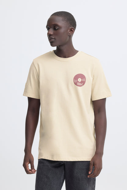 Person wearing a beige t-shirt with a logo on a white background
