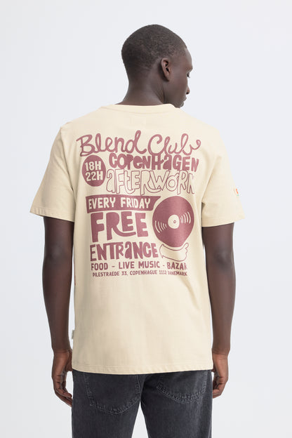 Man wearing a beige t-shirt with text and graphics on the back, standing against a white background