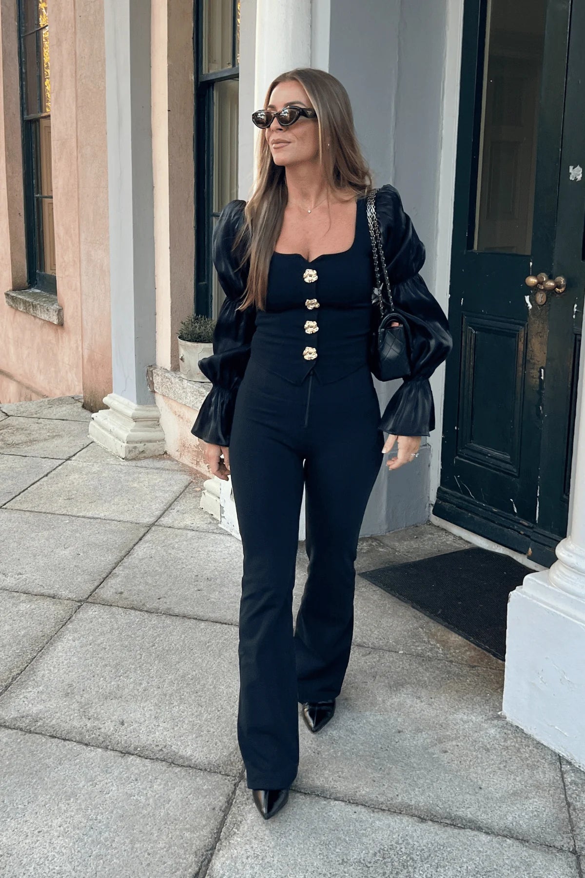 Woman in a black outfit walking outside a building