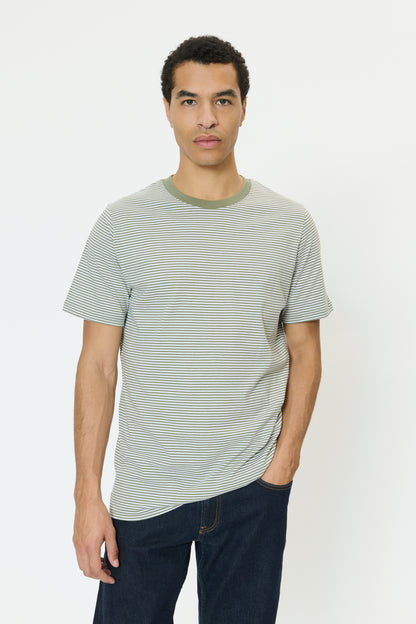 Man wearing a striped t-shirt and dark pants on a white background