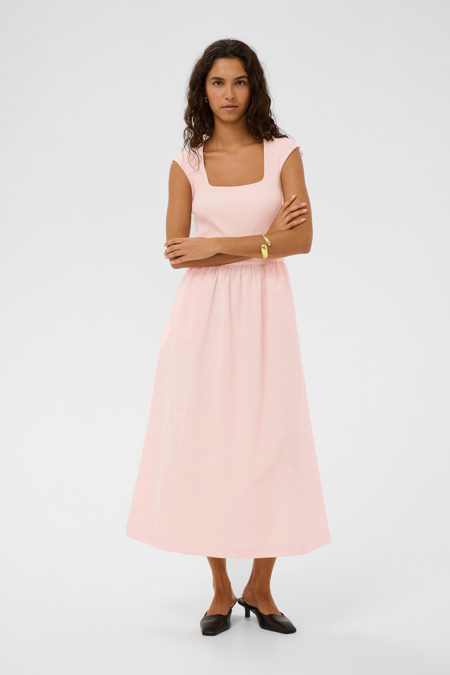 Woman wearing a light pink dress on a white background