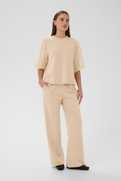 Woman wearing a beige outfit on a white background