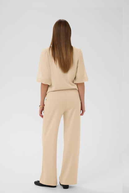 Woman wearing a beige outfit on a white background