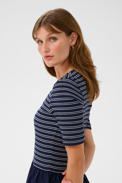 Woman wearing a navy and white striped shirt on a plain background