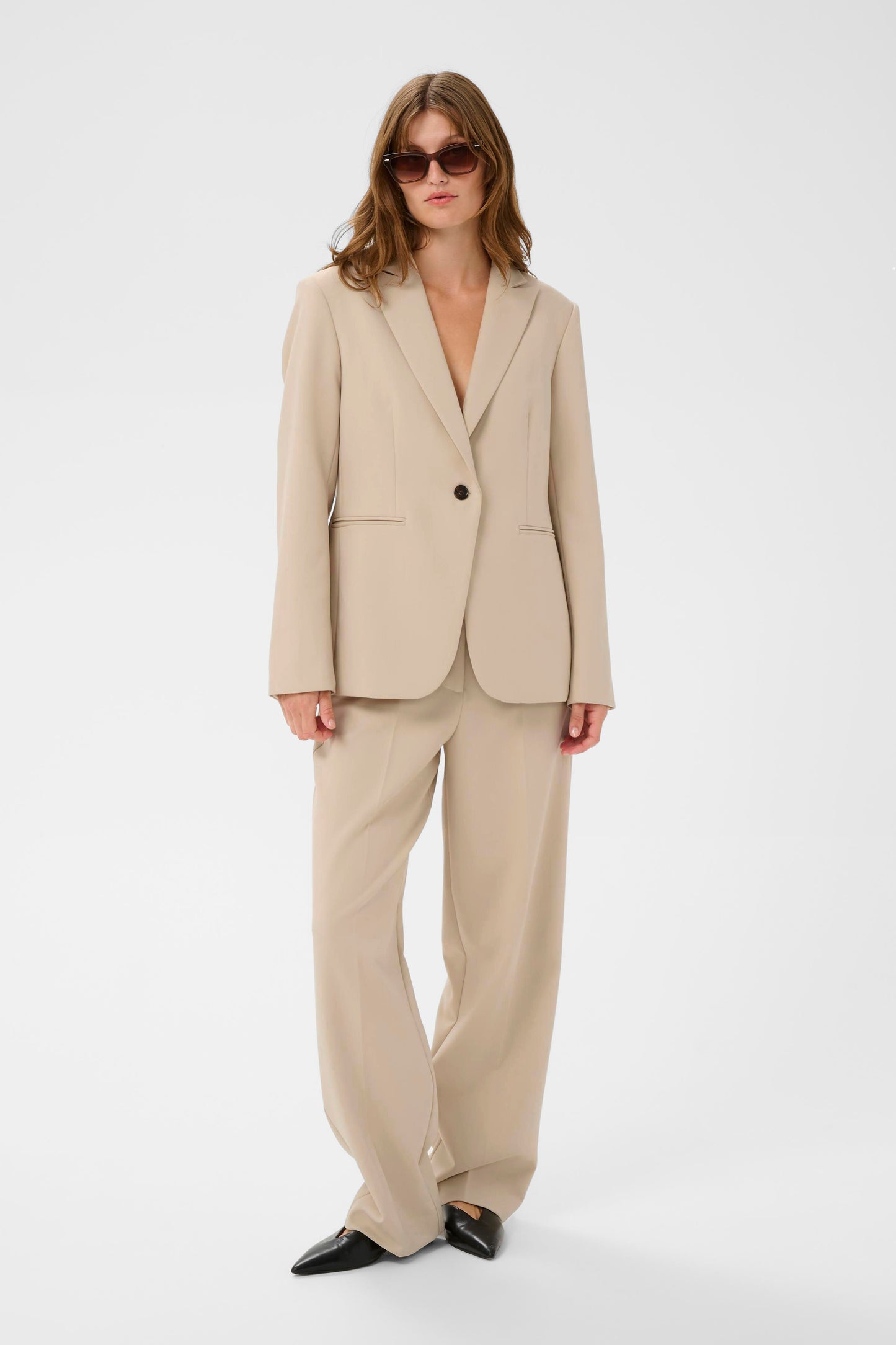 Woman wearing a beige suit on a white background