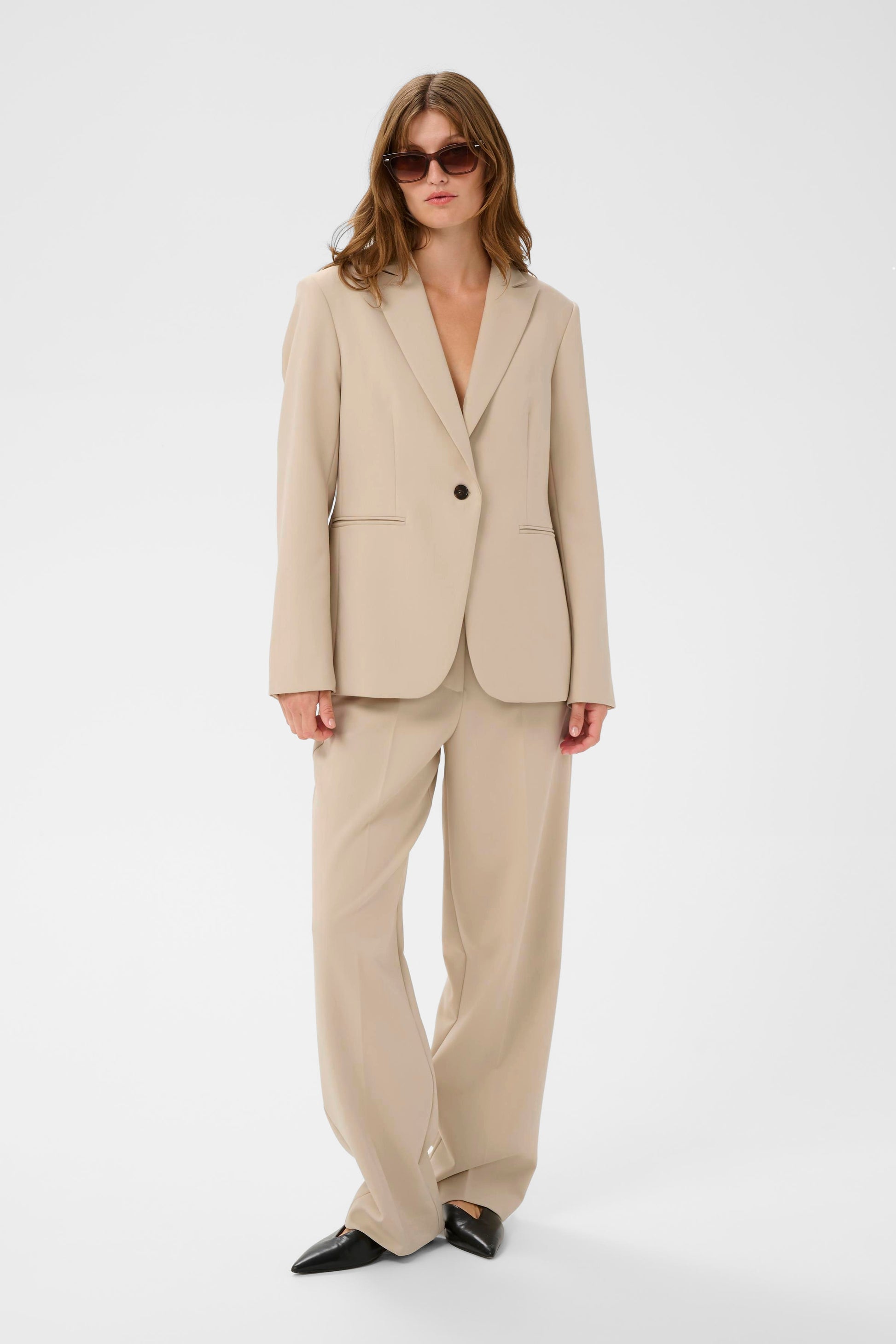 Woman wearing a beige suit on a white background