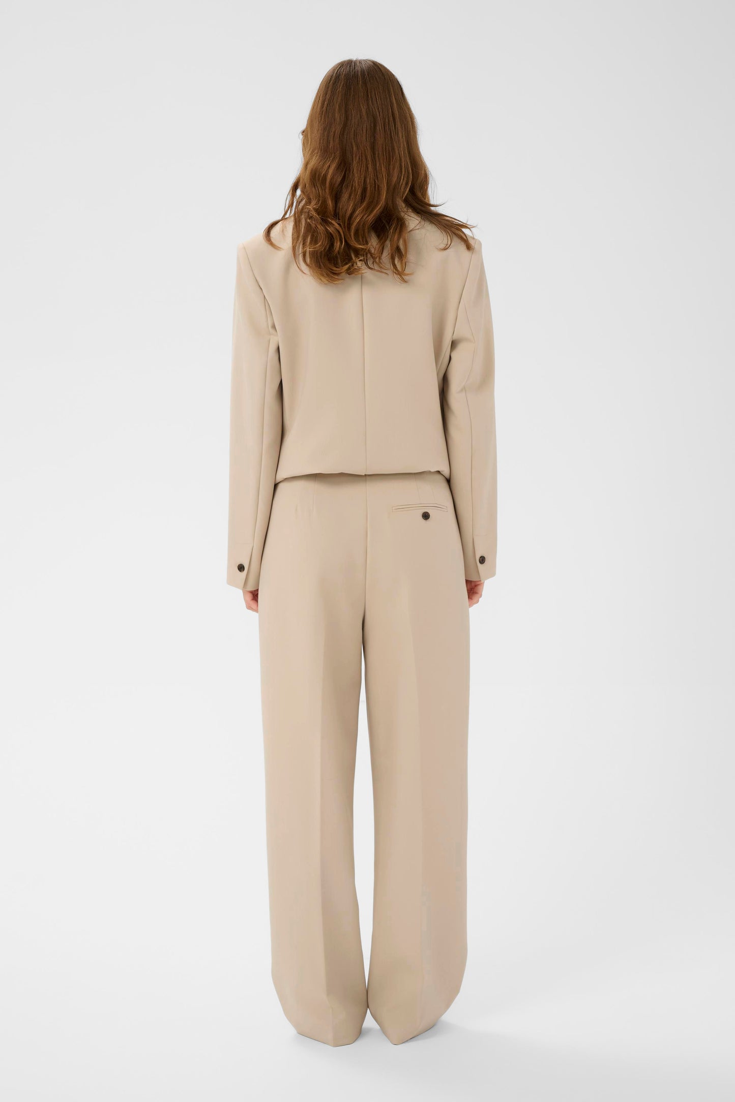 Woman wearing a beige suit on a white background