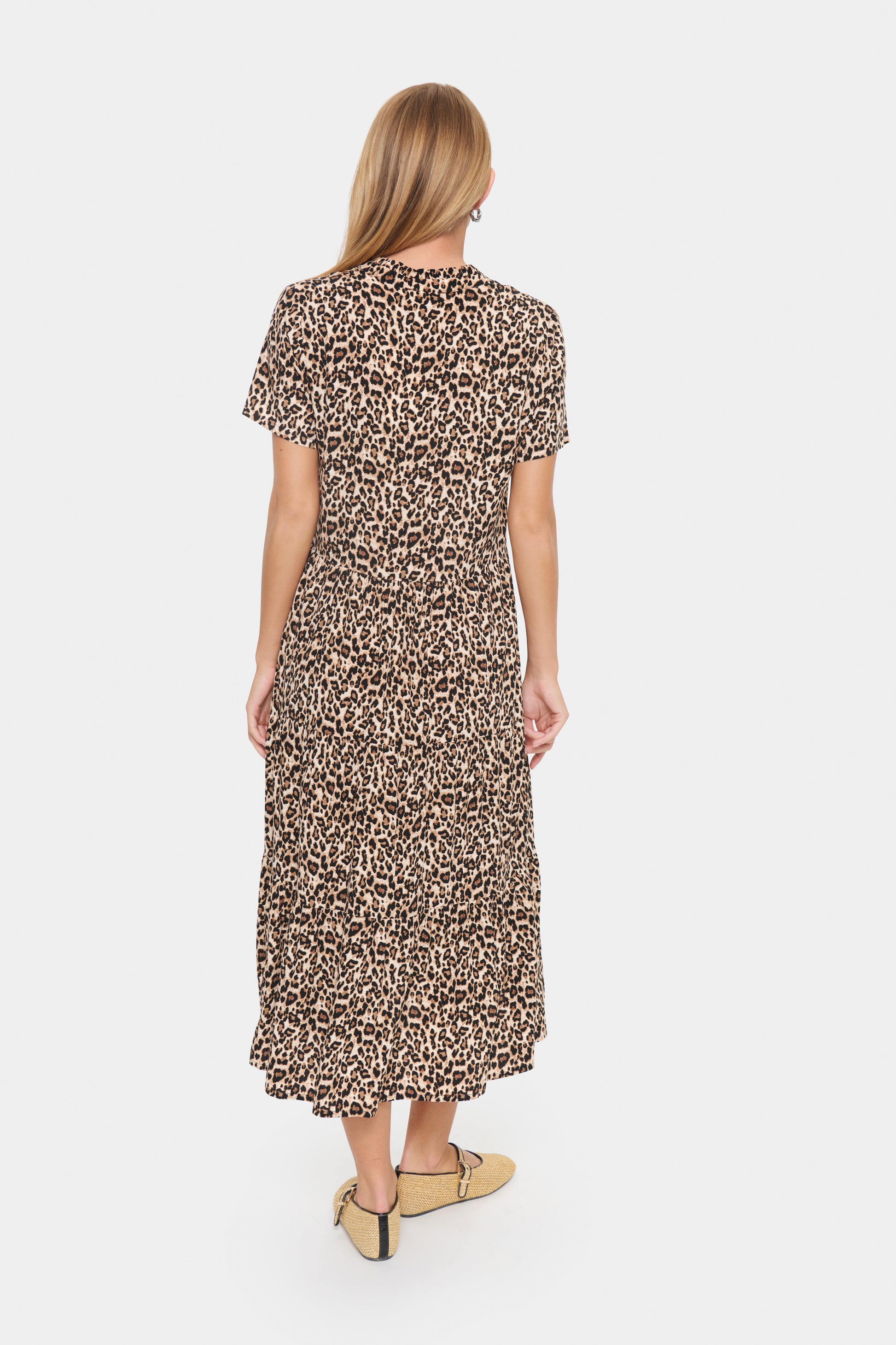 Woman wearing a leopard print dress on a white background