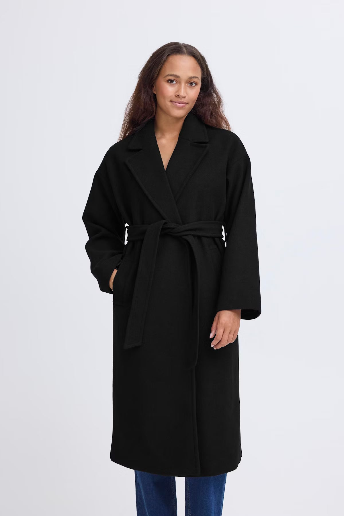 Woman wearing a black coat on a white background