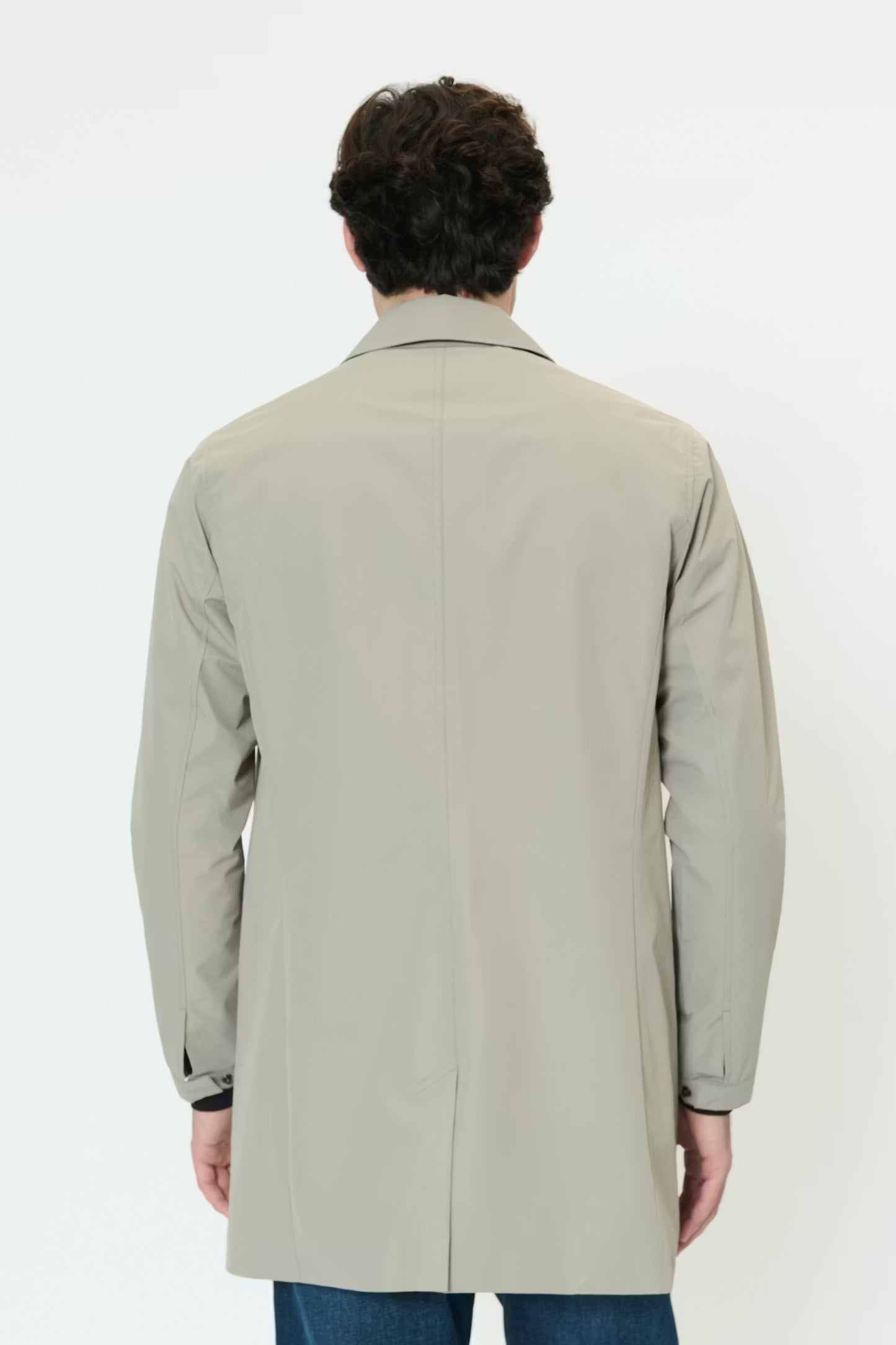 Person wearing a light gray coat on a white background