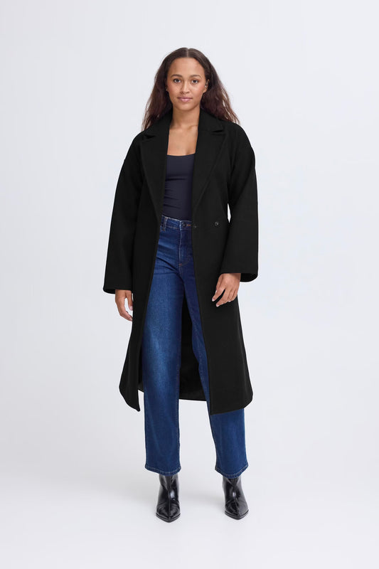 Woman wearing a black coat, blue jeans, and black shoes on a white background