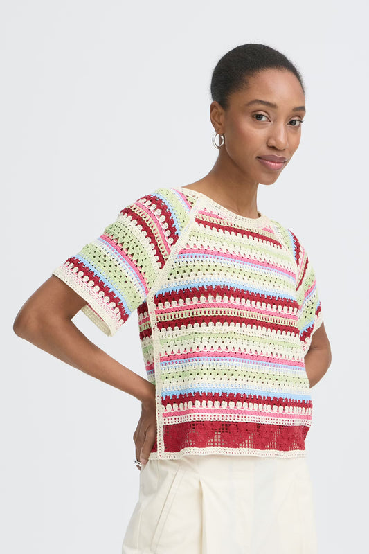 Woman wearing a colorful striped shirt against a white background