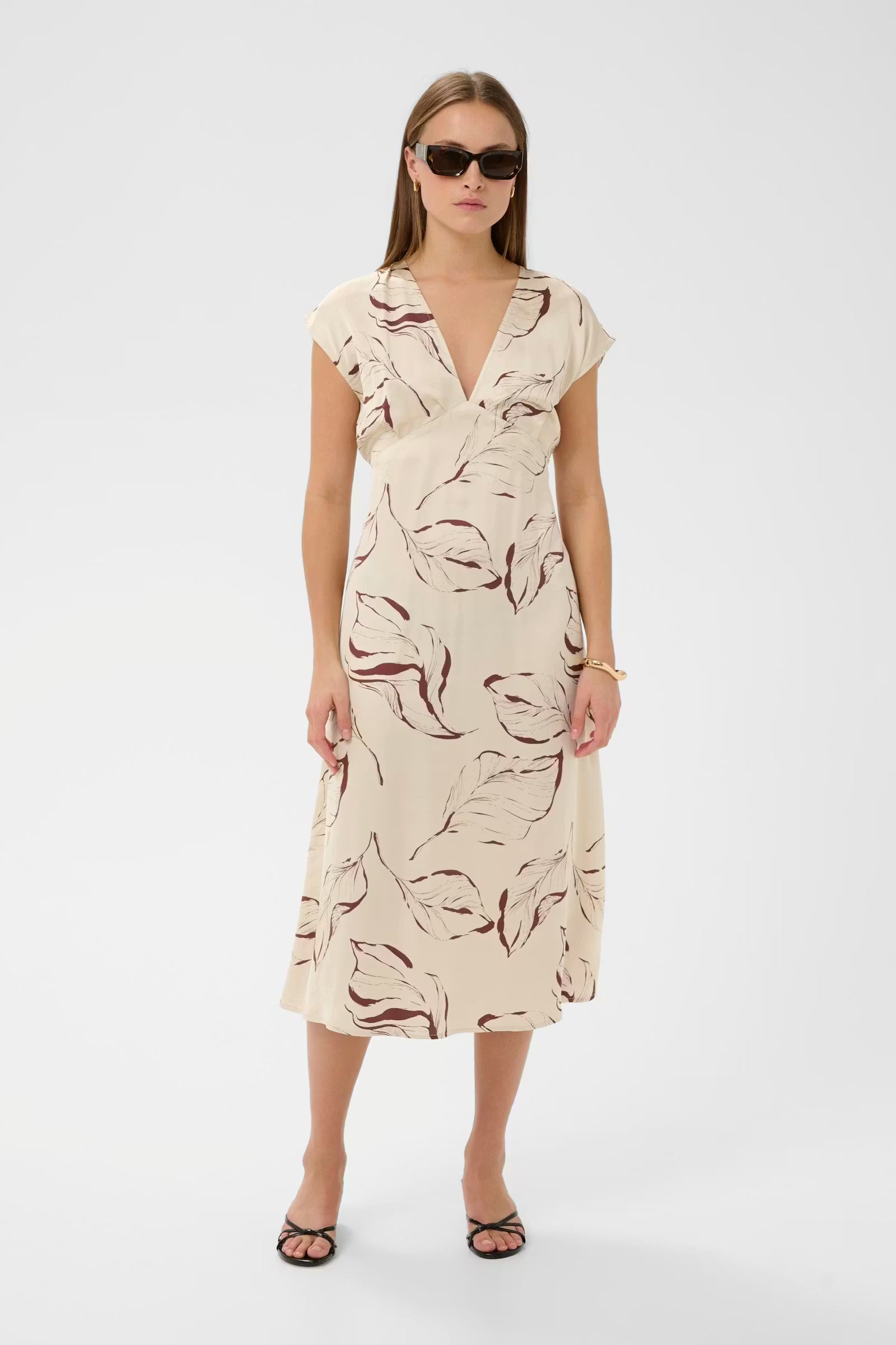 Woman wearing a patterned dress on a white background
