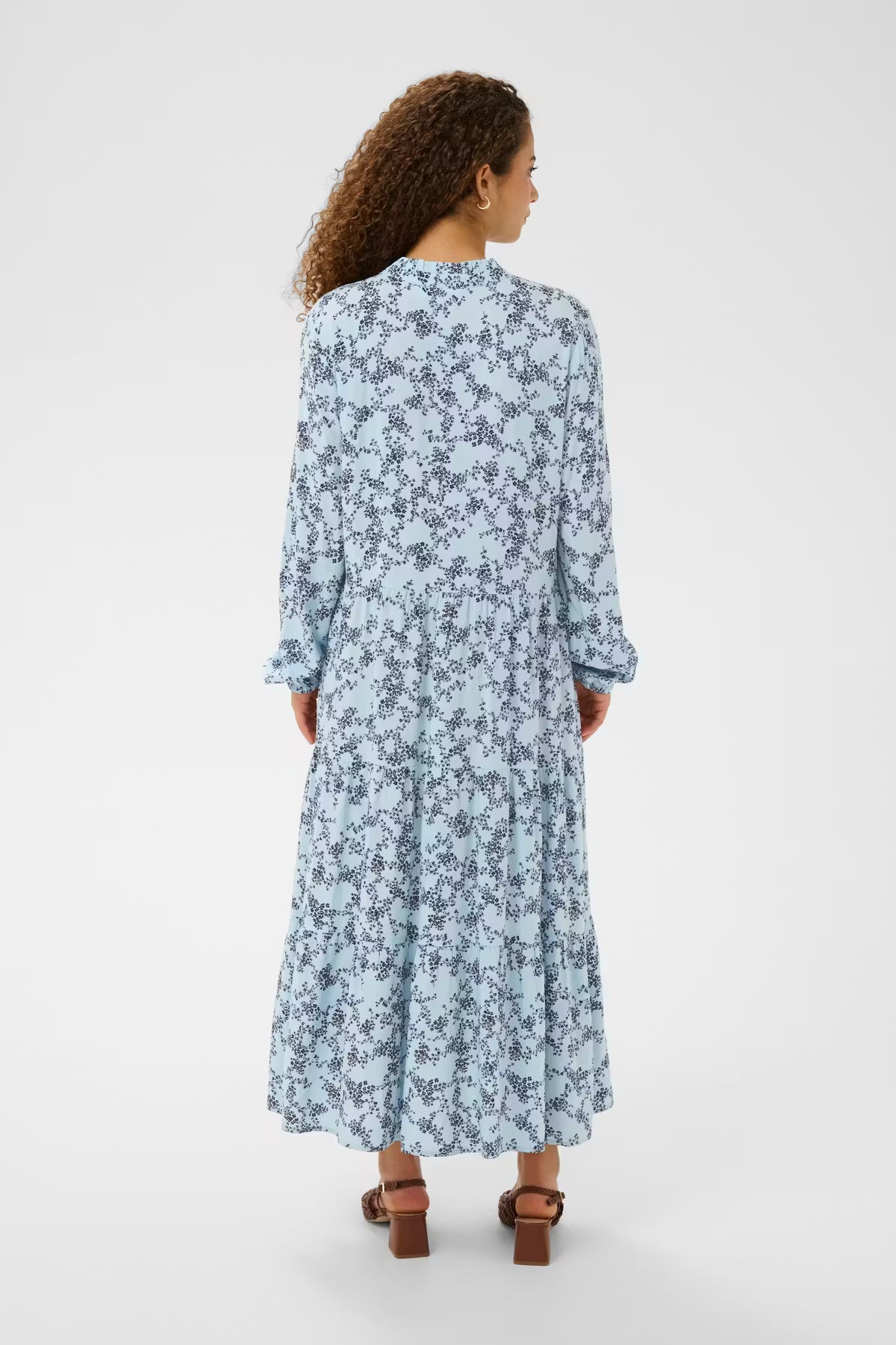 Woman wearing a blue floral dress on a white background