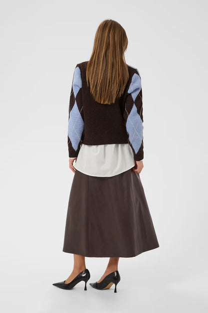 A woman shown from the back wearing a brown knit sweater vest with light blue and white argyle sleeves, a white top, a brown midi skirt, and black heels, against a light gray studio background.