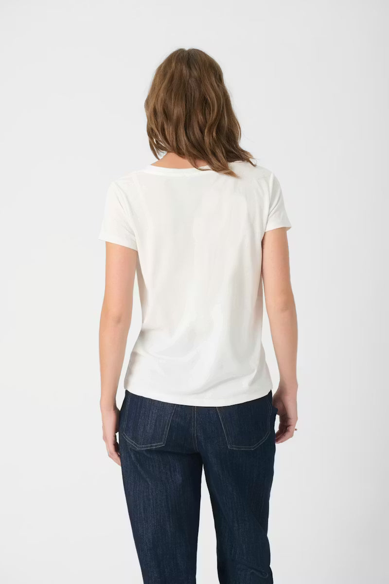 Person wearing a white t-shirt and dark jeans on a white background