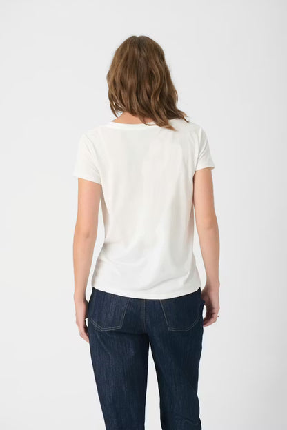 Person wearing a white t-shirt and dark jeans on a white background