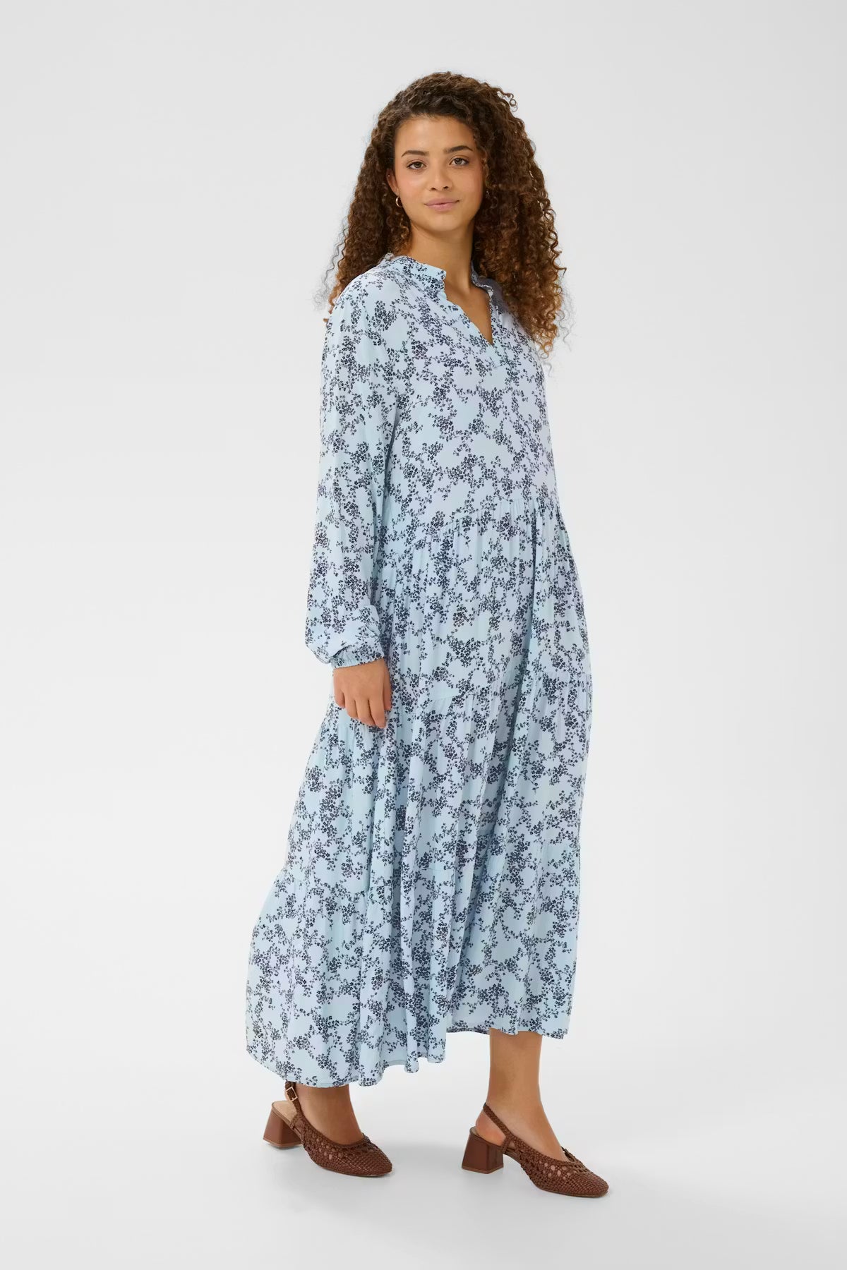 Woman wearing a long floral dress on a white background