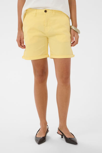 Person wearing yellow shorts on a white background