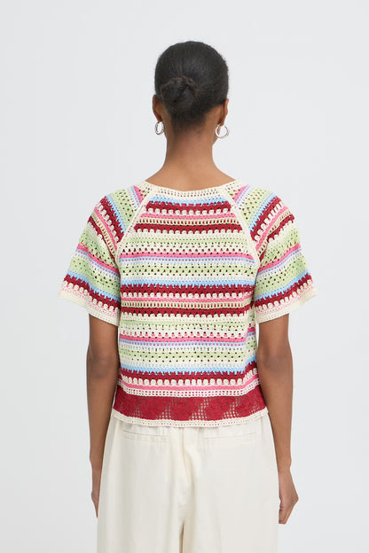 Woman wearing a colorful crochet top on a white background