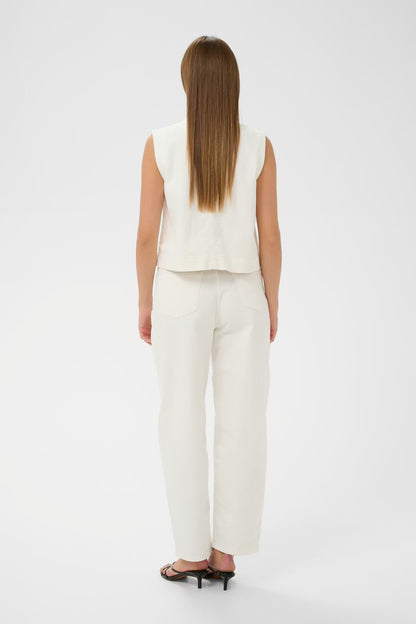 Woman wearing a white sleeveless top and pants on a white background