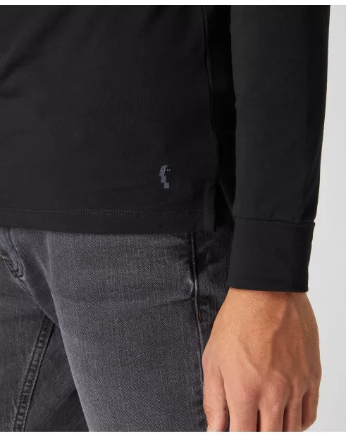 Person wearing a black long-sleeve shirt and gray jeans on a white background