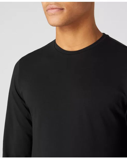 Close-up of a person wearing a black long-sleeve shirt against a plain background