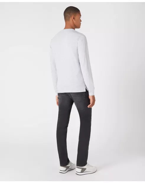 Man wearing a white long-sleeve shirt and black pants on a white background