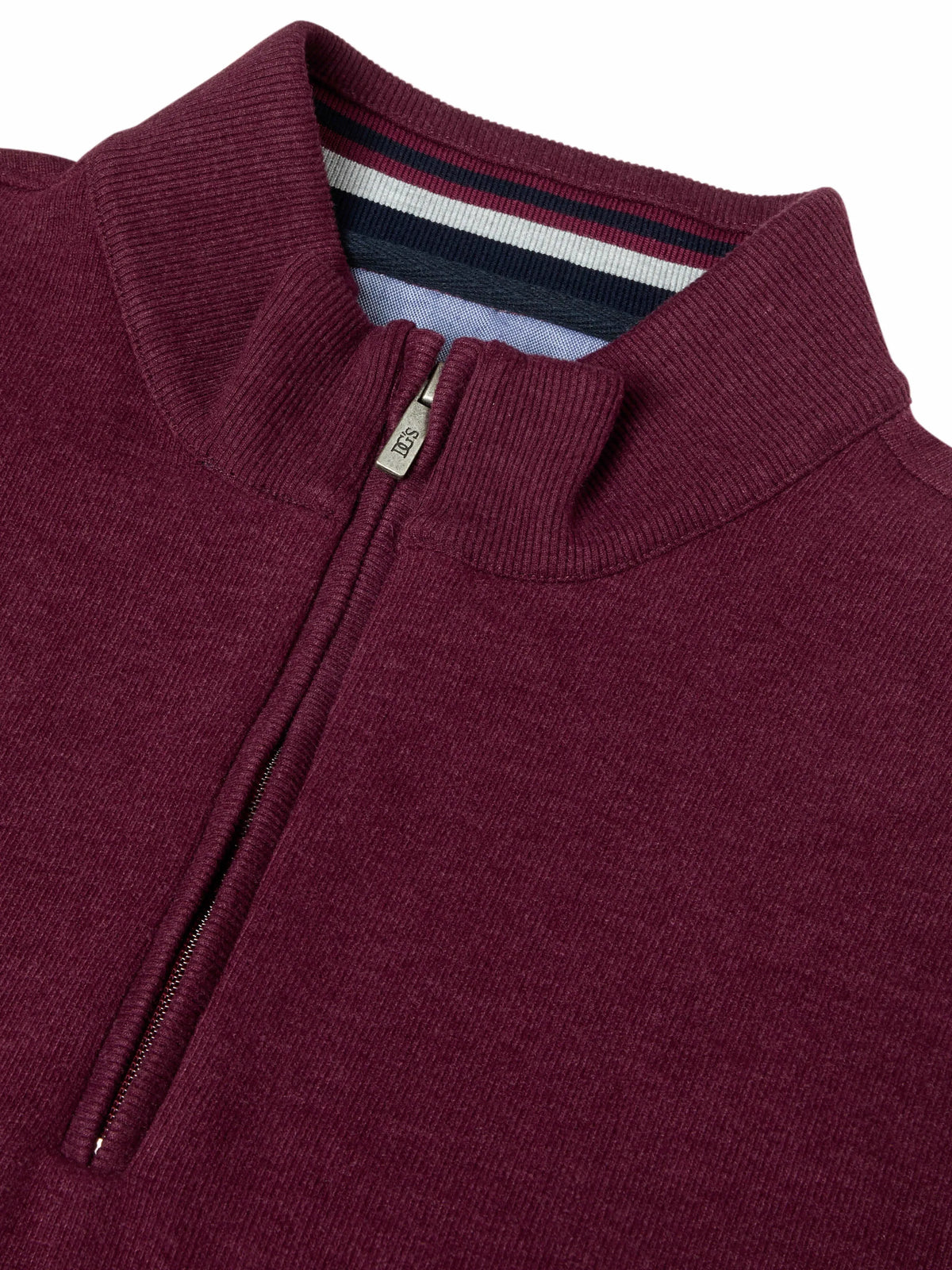 Close-up of a ribbed knit quarter-zip sweater in deep burgundy, showing the collar, zipper pull, and striped inner neck lining.