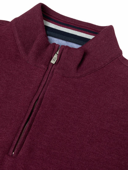 Close-up of a ribbed knit quarter-zip sweater in deep burgundy, showing the collar, zipper pull, and striped inner neck lining.