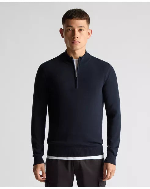 Man wearing a navy blue quarter-zip sweater against a light gray background