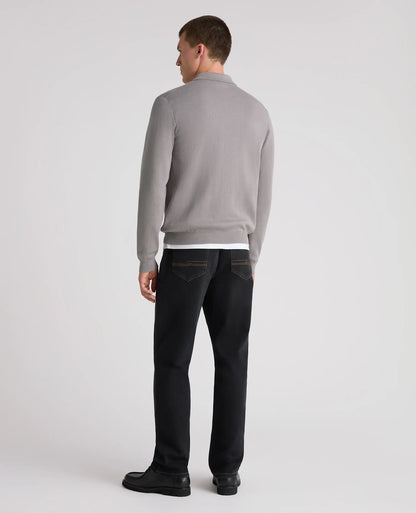 A man shown from the back wearing a light gray long-sleeve knit sweater, dark charcoal jeans, and black shoes, photographed against a clean light gray studio background.