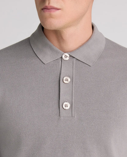 Close-up of a man wearing a light gray ribbed knit polo shirt with a three-button placket.