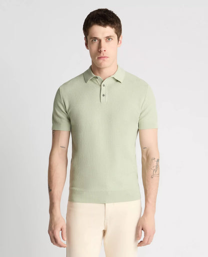 Man wearing a light green ribbed polo shirt against a plain background