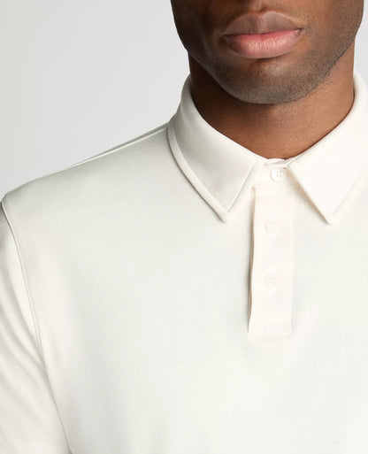 Close-up of a person wearing a white dress shirt against a neutral background