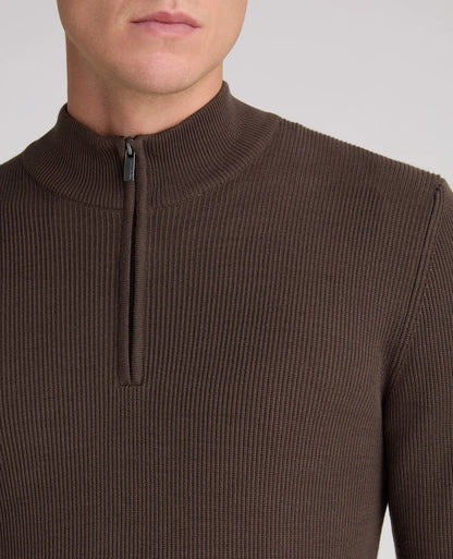 Close-up of a man wearing a ribbed brown half-zip mock neck sweater against a light gray background.